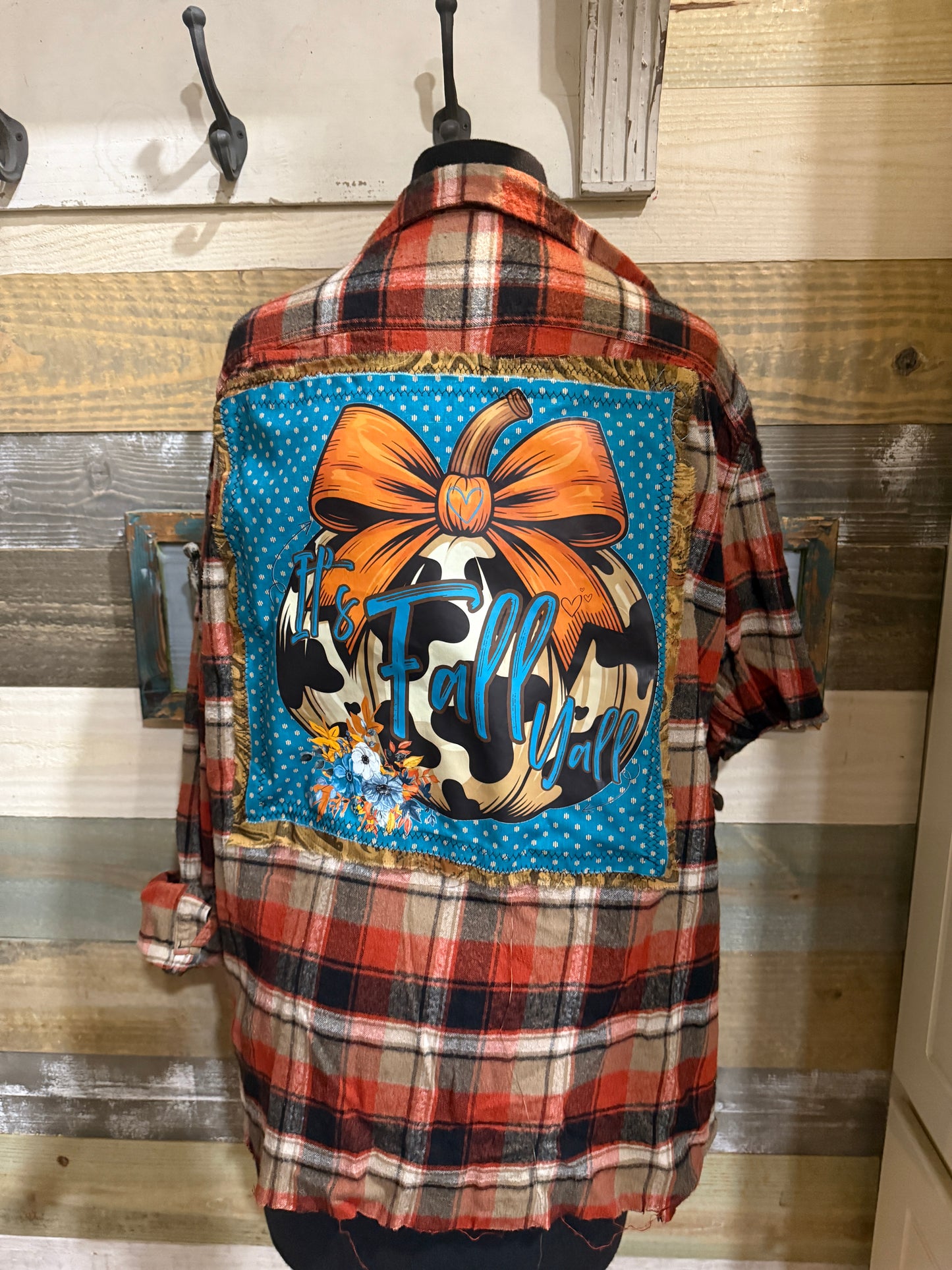 Plaid flannel with a colorful patch featuring a bow and cow print design.