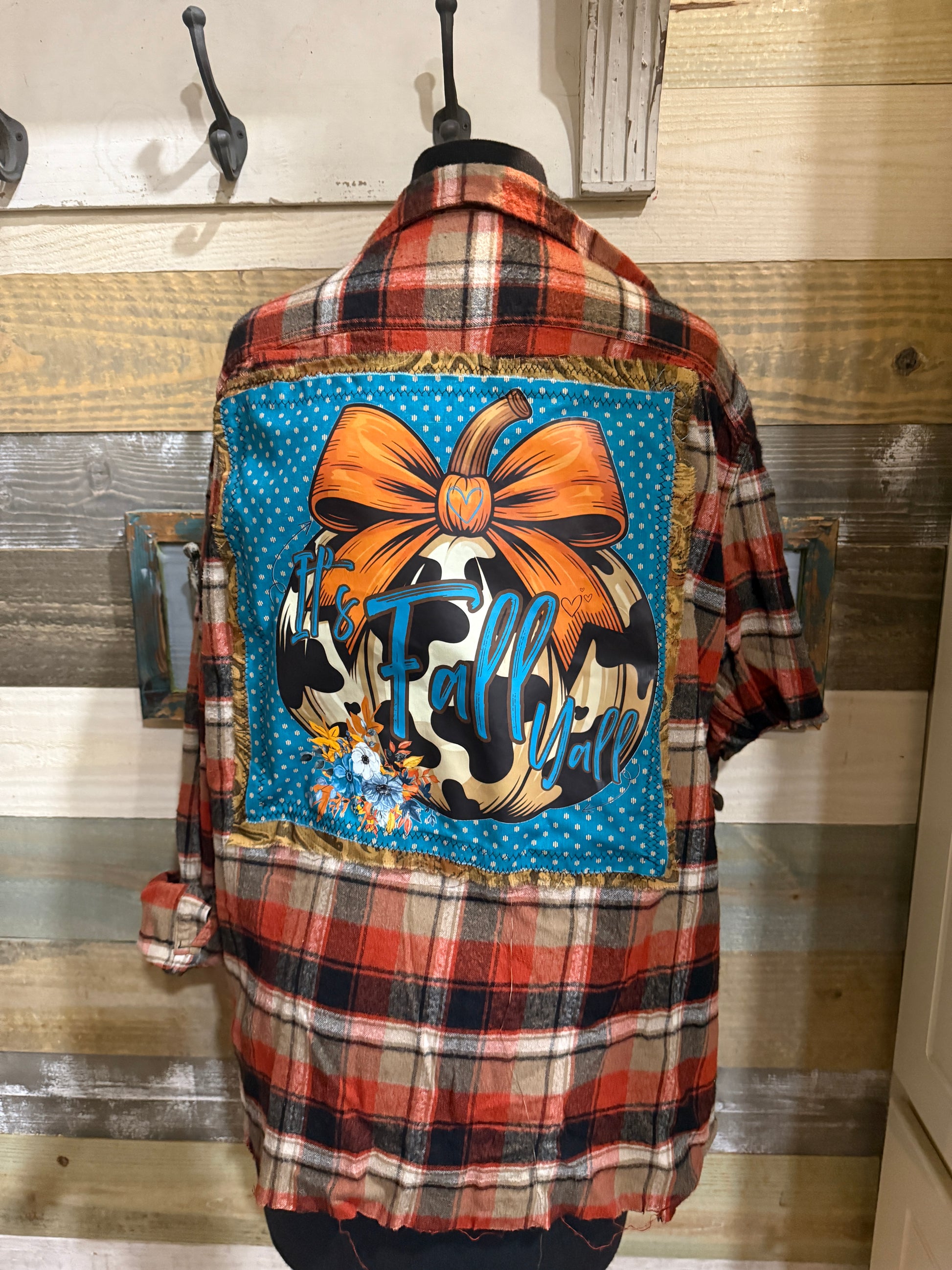 Plaid flannel with a colorful patch featuring a bow and cow print design.